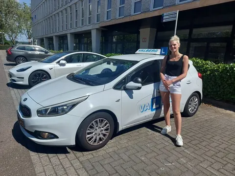 Geslaagde cursist naast de Valberg lesauto