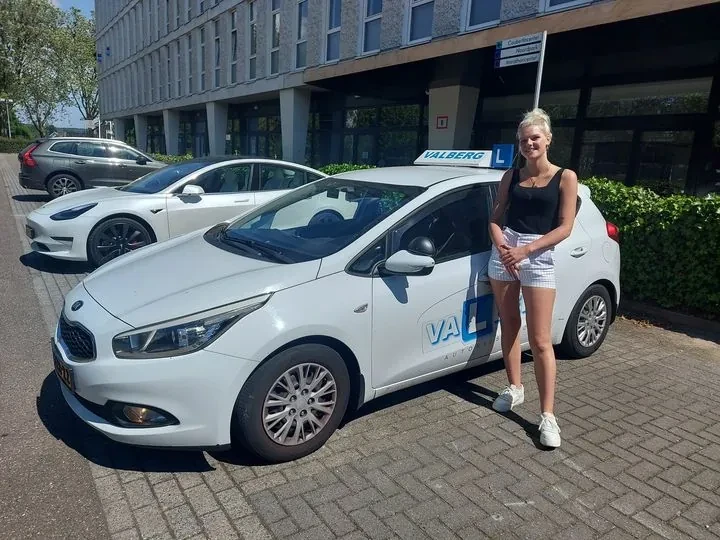 Geslaagde cursist naast de Valberg lesauto