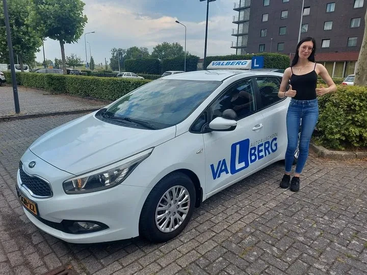 Geslaagde kandidaat naast de lesauto van Autorijschool Valberg in Valkenburg