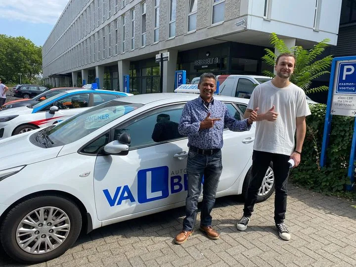 Rijinstructeur van Autorijschool Valberg met een geslaagde leerling bij de lesauto